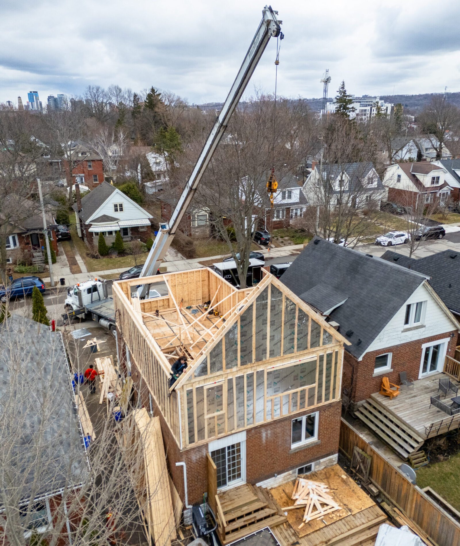 Aerial view of crane-assisted second storey addition with structural framing in Hamilton